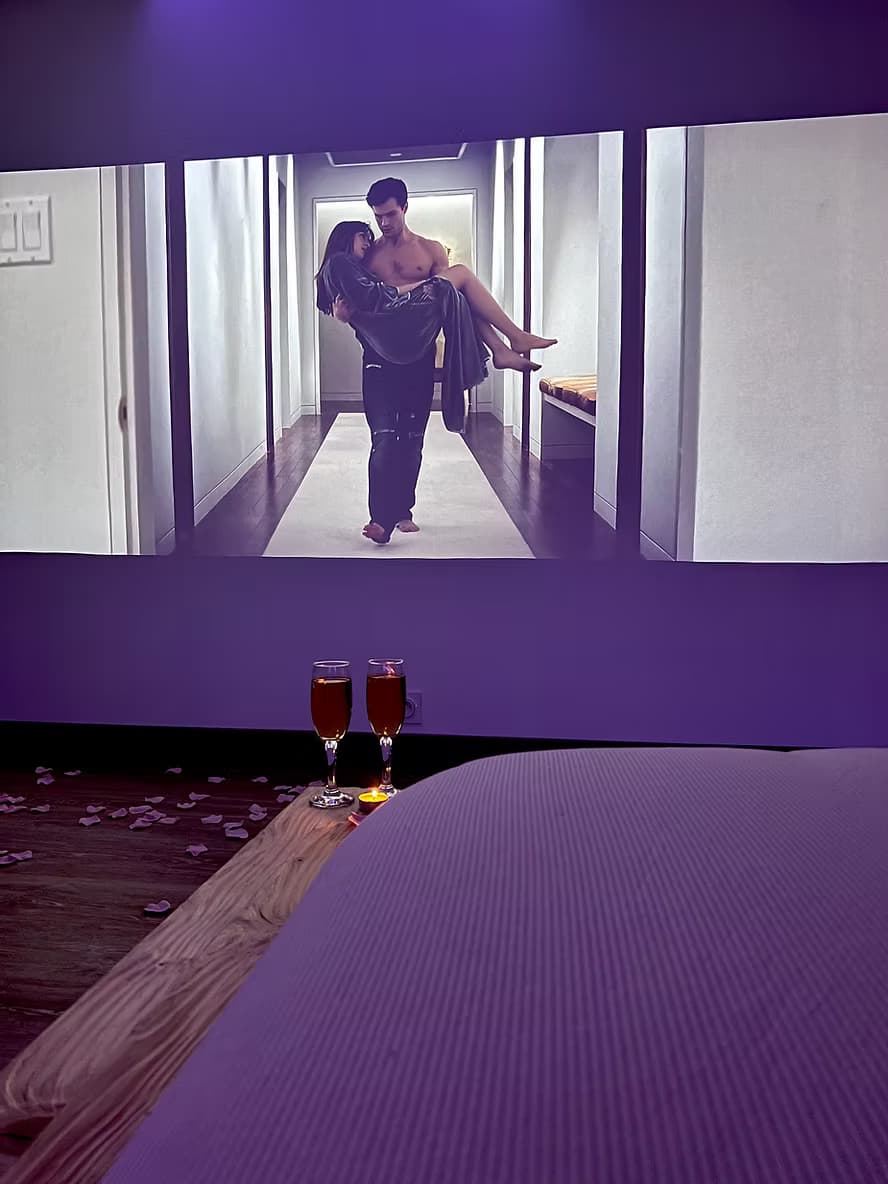Lit Suite B Spa face à l'écran cinéma avec Prosecco pour soirée à deux