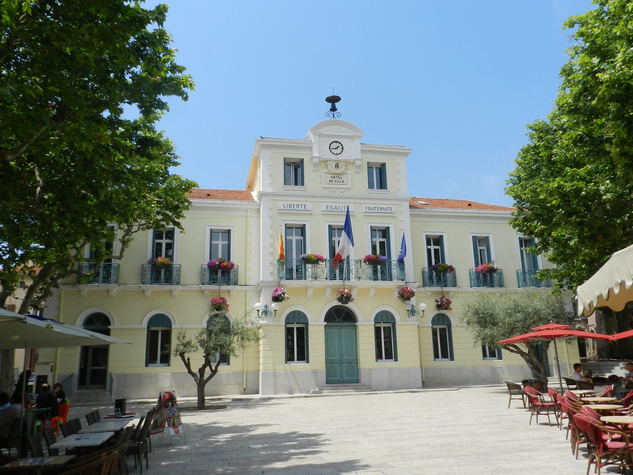 Provençal town hall of Le Beausset with its yellow façade, green shutters and plane-tree-shaded square